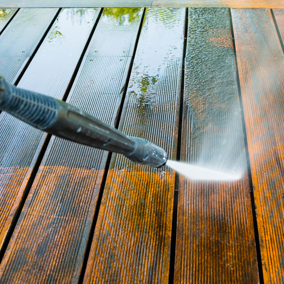 a jet wash cleaning a wooden decking